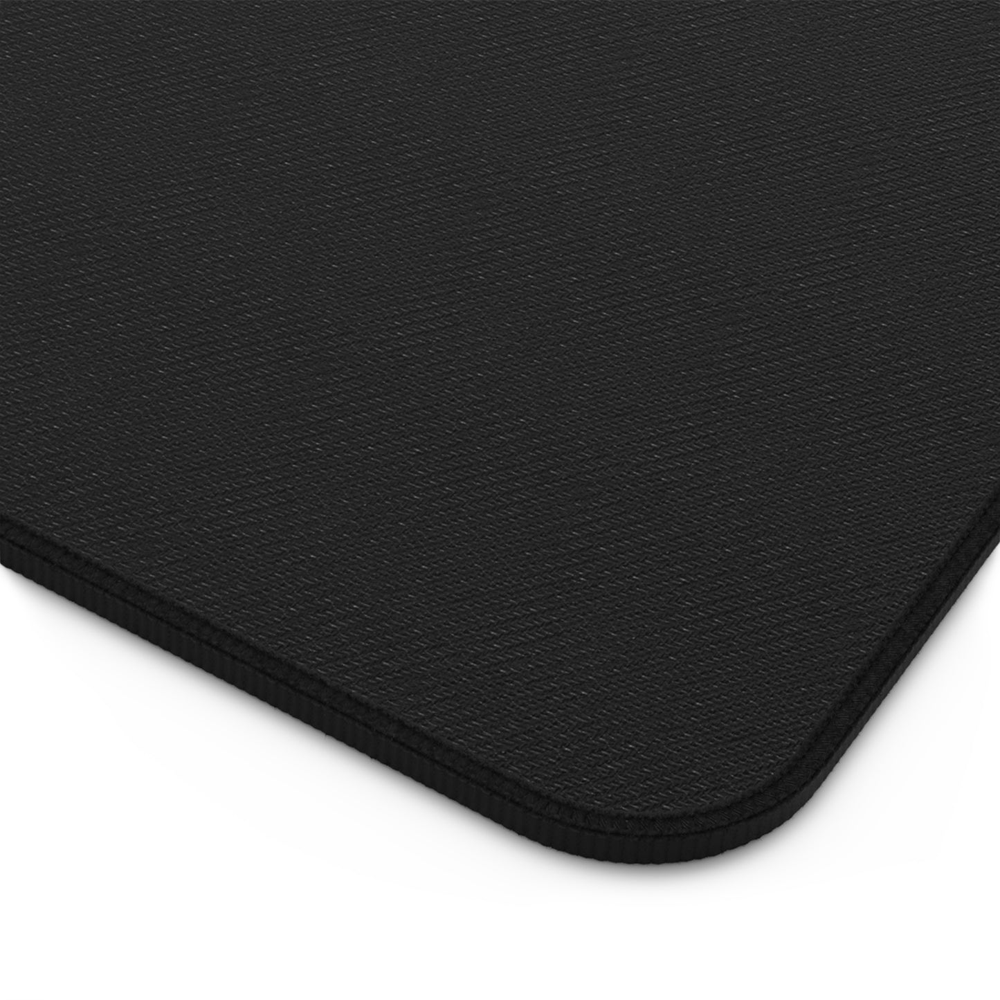 Close-up of a black custom desk mat featuring a textured surface and hemmed edge for durability.