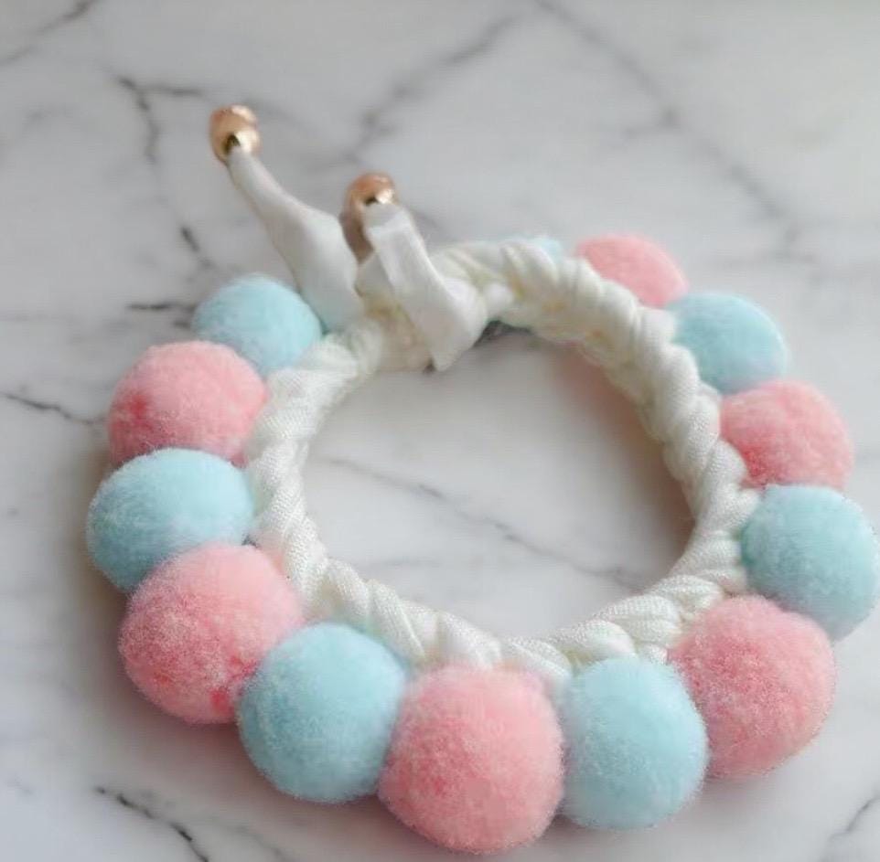 A handcrafted pet collar with a circular design featuring a main circle in pink and blue.