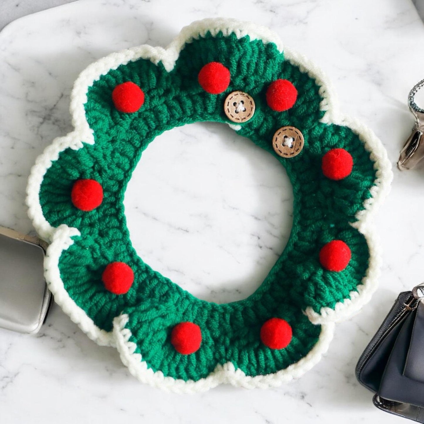 A green Christmas themed collar, with small red balls on it.